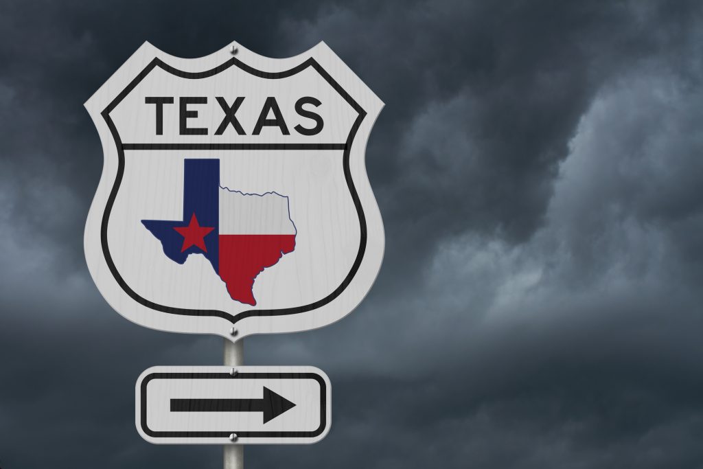 Texas road sign with dark sky behind it