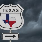 Texas road sign with dark sky behind it