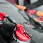 Auto technician using suction tools to install a new windshield during a professional windshield replacement service.